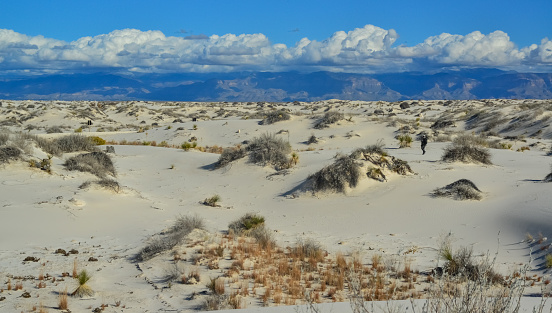 USA, NEW MEXICO - NOVEMBER 23, 2019: A tourist walks in the sand dunes,  White Sands National Monument, New Mexico, USA
