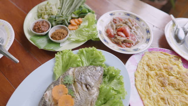 Close-up Papaya salad with steamed tilapia and omelet on the table. Isaan food , Thai food