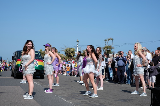 Eastbourne, United Kingdom - May 27 2023: Crowds gather in bright sunshine along the seafront of this popular seaside town to enjoy the Eastbourne Carnival, Eastbourne Carnival 2023, Eastbourne, England, United Kingdom