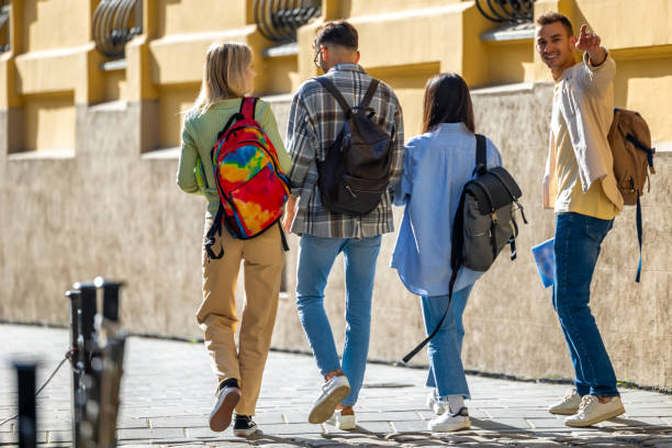 istock Students walking in college campus after classes carrying backpacks going to lessons. 1924871213