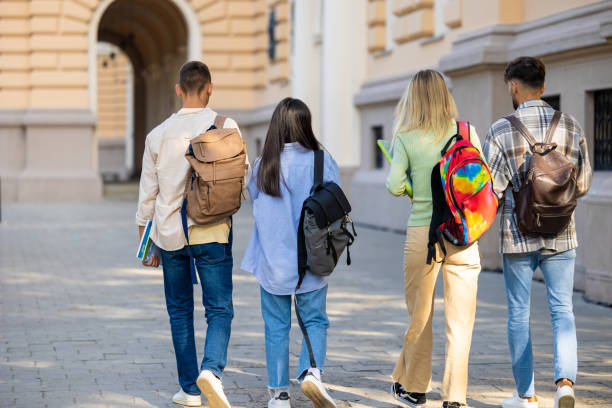 istock Students walking in college campus after classes carrying backpacks going to lessons. 1924871221