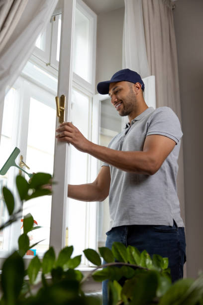 istock Bearded man washing dusty window in apartment. 1924941575