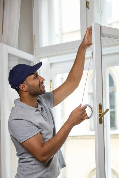 istock Young man putting sealing tape on window in house. 1924942080