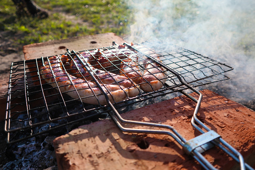 Delicious german sausages on the barbecue grill. barbecue grill at bbq party in summer garden. Sausages on charcoal grill