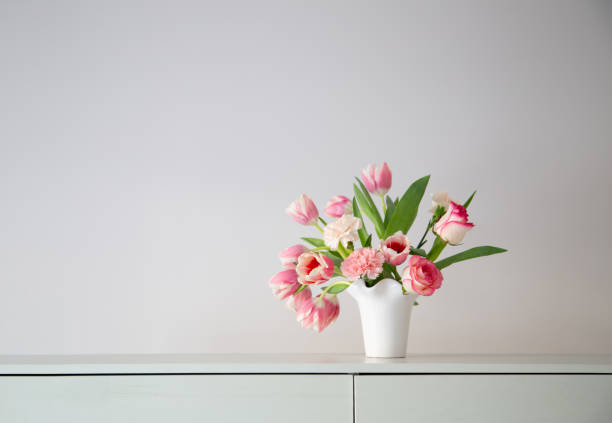 istock pink spring flowers in white ceramic vase in modern home interior 1925000459