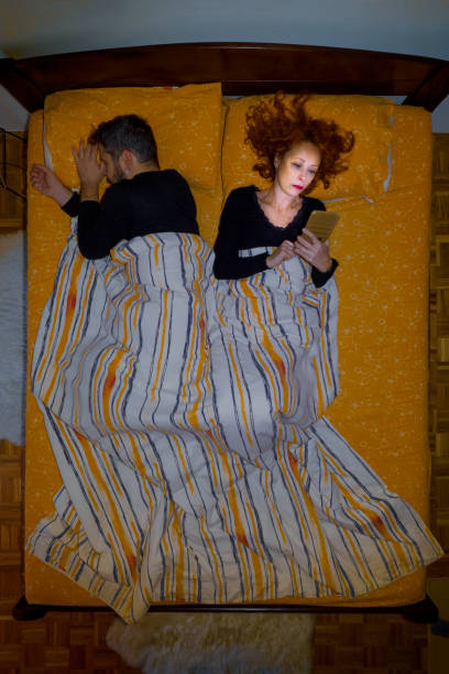 uzależnienie od telefonu nocnego - sleeping lying on back couple bed zdjęcia i obrazy z banku zdjęć