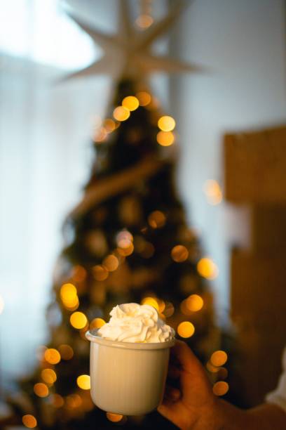 istock New Year's mug with cream next to the Christmas tree 1925046747