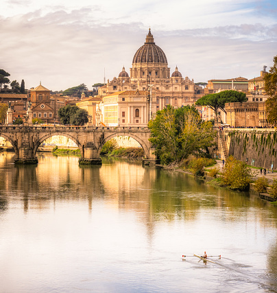 Rome, Italy - A rower on the river Tiber in Rome, with the dome of St Peter's on the horizon.