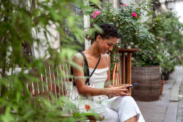 istock Young woman with a mobile phone sitting on the bench 1925060445