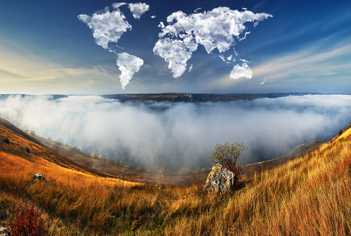 clouds in the form of a world map over the river canyon. Travel and landscape concept. autumn morning