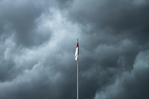 red and white indonesian flag with dark couldy sky on the background
