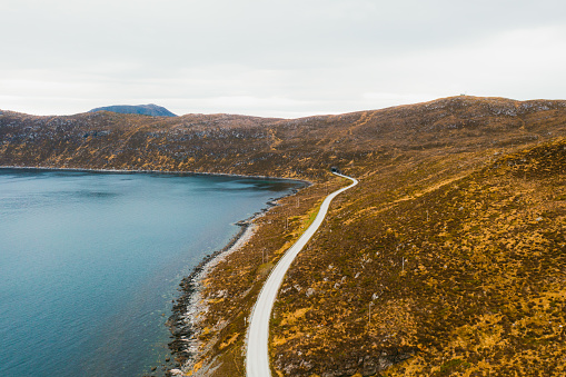High-angle photo of idyllic road by the sea between the small Norwegian towns on the island during summer in Scandinavia