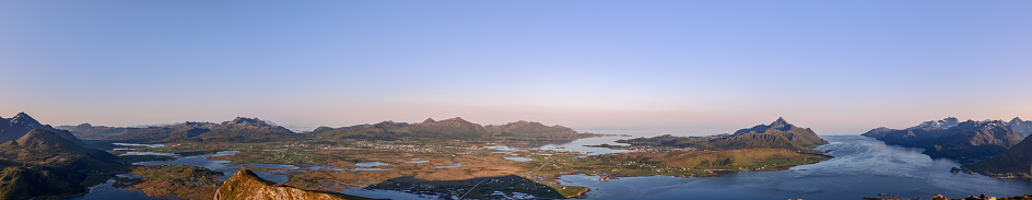 A sweeping panorama of Lofoten's wild beauty from Offersoykammen, showcasing the midnight sun's glow on Norway's dramatic mountainous archipelago