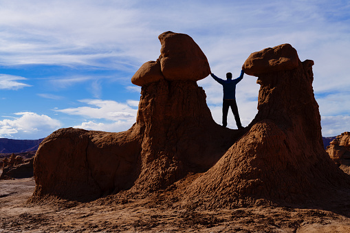 Man in Silhouette Standing Between Rock Hoodoo Formations - Goblin shaped rocks in surreal desert landscape.