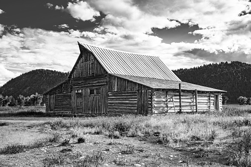 Retro Art image of the publicly owned historic T. A. Moulton Barn landscape and cloudscape in Grand Teton National Park along Mormon Road Wyoming.