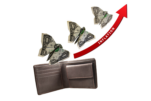 Inflation concept. Money in the shape of butterflies flying out of wallet with red arrow and inflation text. Clipping path.