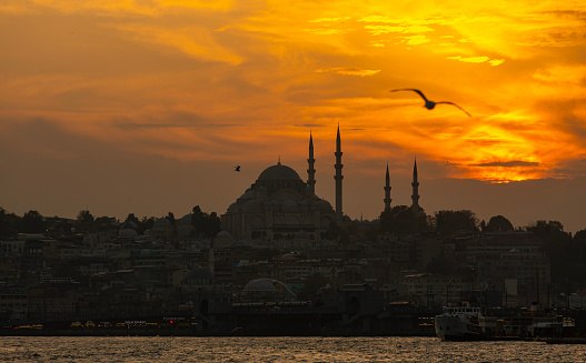 Silhouette of Suleymaniye Mosque at sunset. Golden sky and clouds.