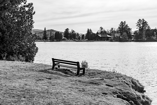 Mirror Lake, Lake Placid with park bench in the foreground, Lake Placid, New York State.