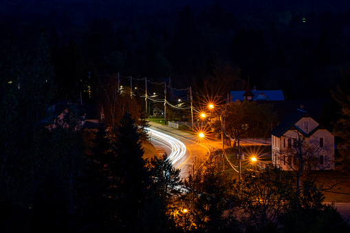Mirror Lake, Lake Placid, New York State. Long exposure of car lights heading into Lake Placid Town at night.
