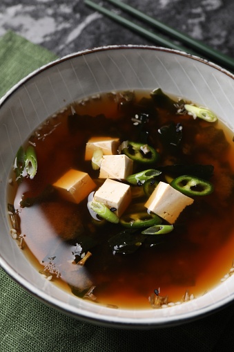 Bowl of delicious miso soup with tofu on table