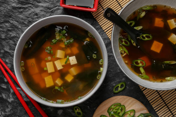 istock Delicious miso soup with tofu served on black textured table, flat lay 1925184741