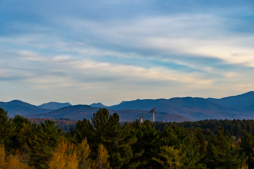 View at sunset over the autumnal leaf coloured forests near Mirror Lake, Lake Placid. The ski lift is visible.