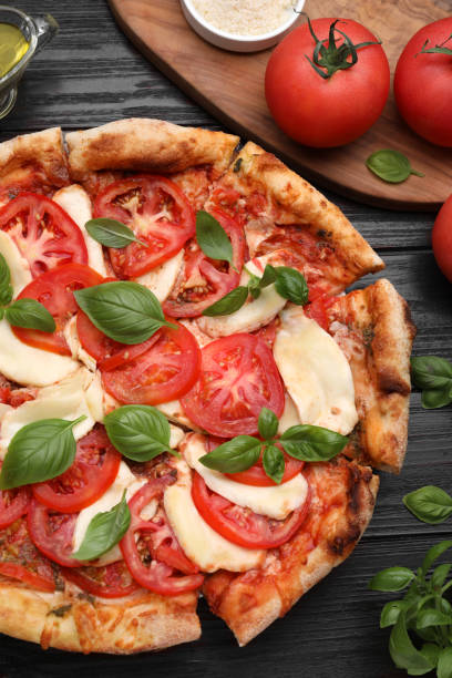 istock Delicious Caprese pizza on black wooden table, flat lay 1925195389