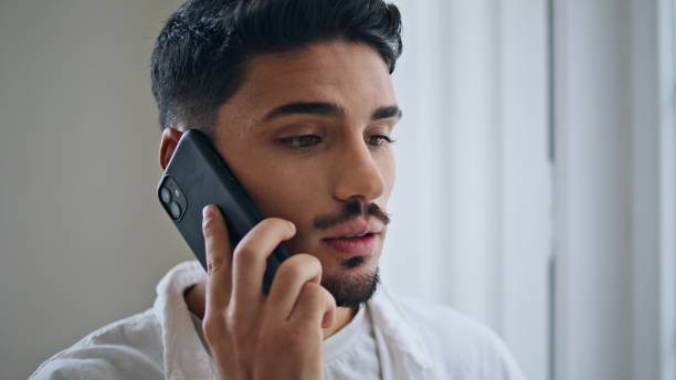 istock Focused guy call cellphone at flat portrait. Serious man speaking telephone 1925198624