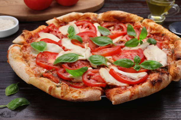 istock Delicious Caprese pizza on black wooden table, closeup 1925198629