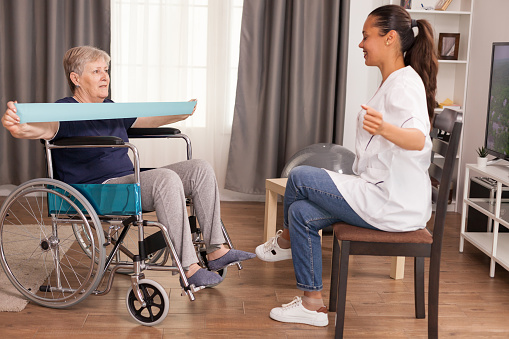 Doctor doing rehab with senior woman in wheelchair. Training, sport, recovery and lifting, old person retirement home, healthcare nursing, health support, social assistance, doctor and home service