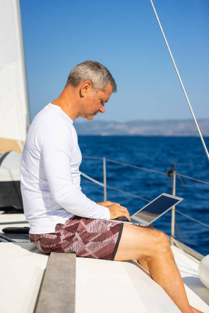 istock Businessman with laptop on sailboat 1925266458