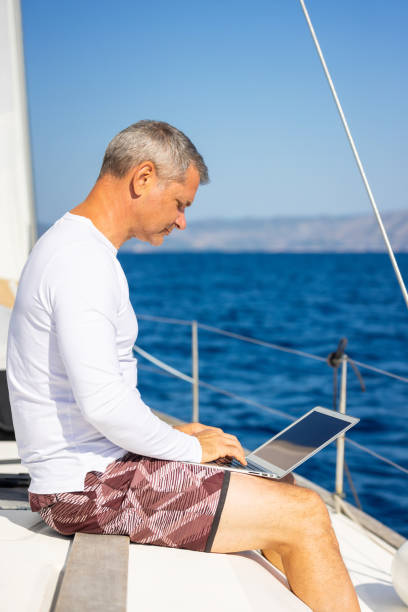 istock Businessman with laptop on sailboat 1925266992