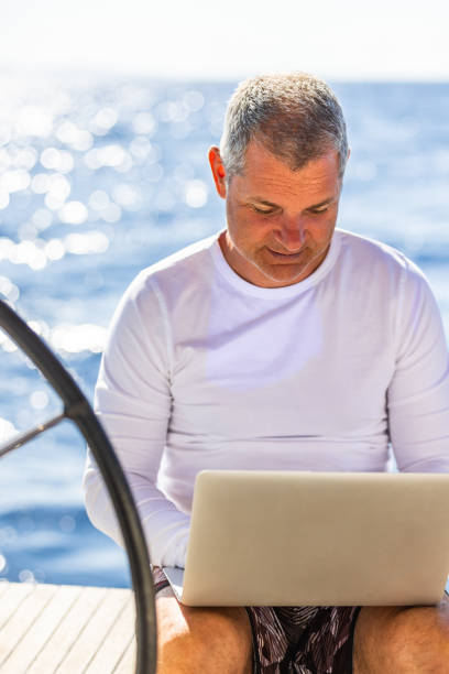 istock Businessman with laptop on sailboat 1925272223