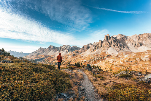 Achievement of male hiker standing with enjoying the massif Des Cerces in Claree Valley during hiking trail in French Alps, France