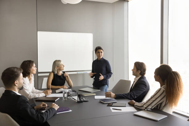 istock Confident young Indian manager presenting project report to diverse team 1925279575