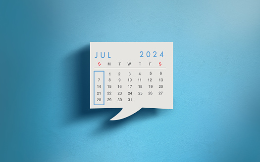 2024 calendar in speech bubble, month of July. Calendar on blue wall.
