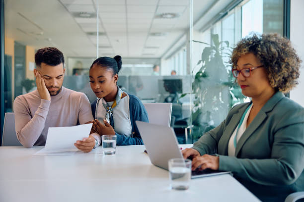 istock Young multiracial couple reading documents during a meeting with insurance agent in the office. 1925286943