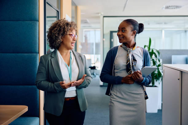 istock Black businesswoman communicating with mature colleague while going through the office. 1925289488