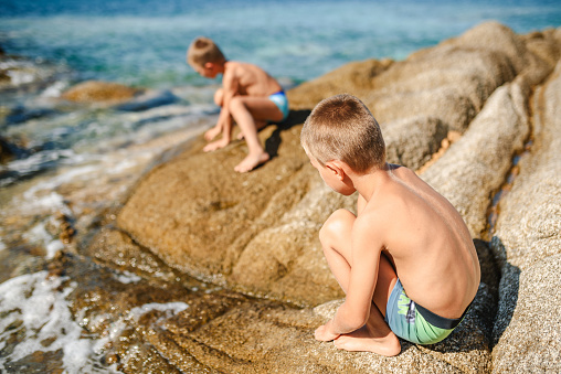 Two boys playing by the sea. Summer vacation photo.