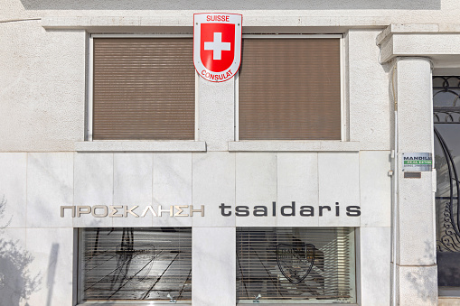 Thessaloniki, Greece - October 22, 2023: Switzerland Coat of Arms Cross Symbol at Suisse Consulat Building at Leof Nikis Street Sunny Autumn Day.