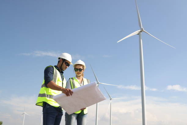 istock Electrical  engineers working on installation plans by drawing blueprints with coworkers in wind farms 1925321851