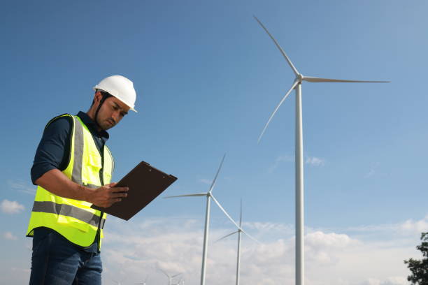 istock Blue collar worker at electricity site. Windmill farm 1925322404