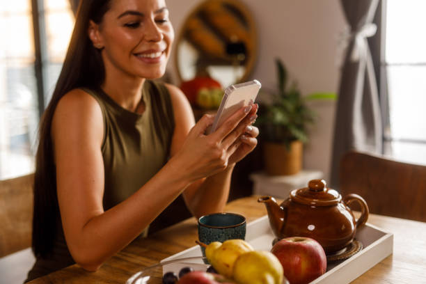 istock Woman enjoying a cup of tea and using smart phone 1925344497