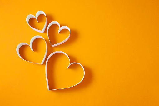 Paper  hearts on yellow background with copy space