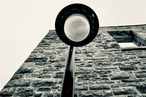 Old fashioned street light in front of a turn of the century stone building.