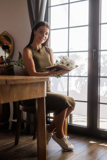 istock Holding an open book with daisy flowers inside 1925350591