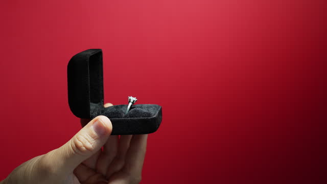 Will you marry me? Male hands holding black velvet box with engagement ring