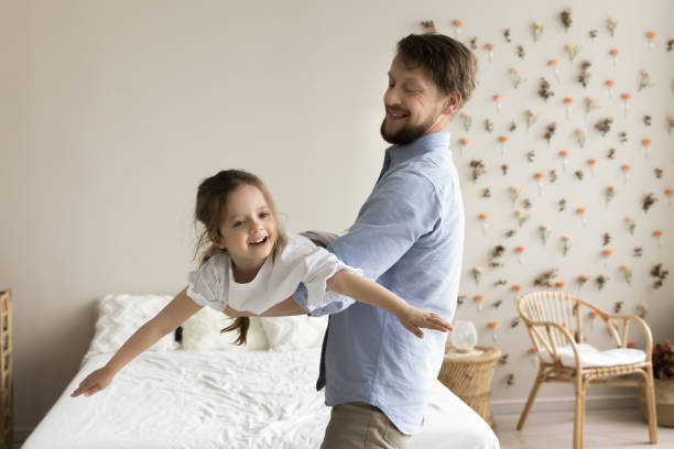 istock Cheerful dad holding playful kid on arms in air 1925375977