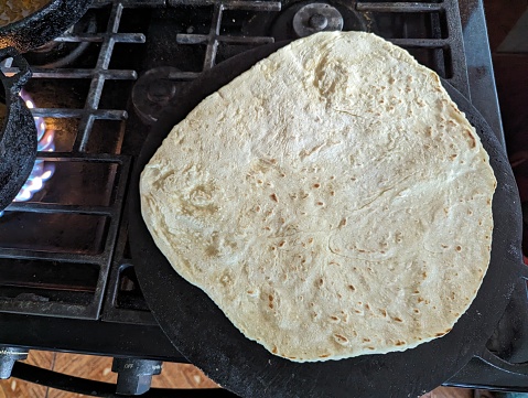 Sada roti being cooked on a tawa or tava in a kitchen in Bejucal, Trinidad and Tobago.