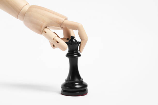 istock Robot with black chess piece on white background. Wooden hand representing artificial intelligence 1925414046